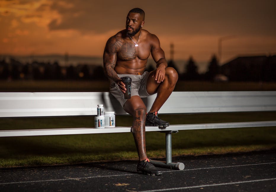 Hombre atlético con suplementos deportivos en pista al atardecer